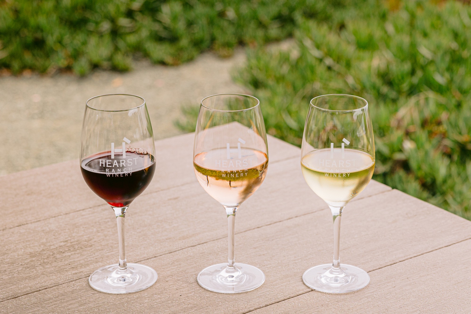 Woman pouring glass of Hearst Ranch Winery red wine.